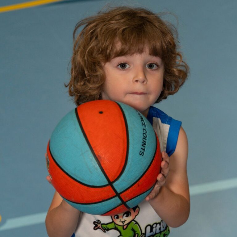 toddler holding a basketball in our preschool class