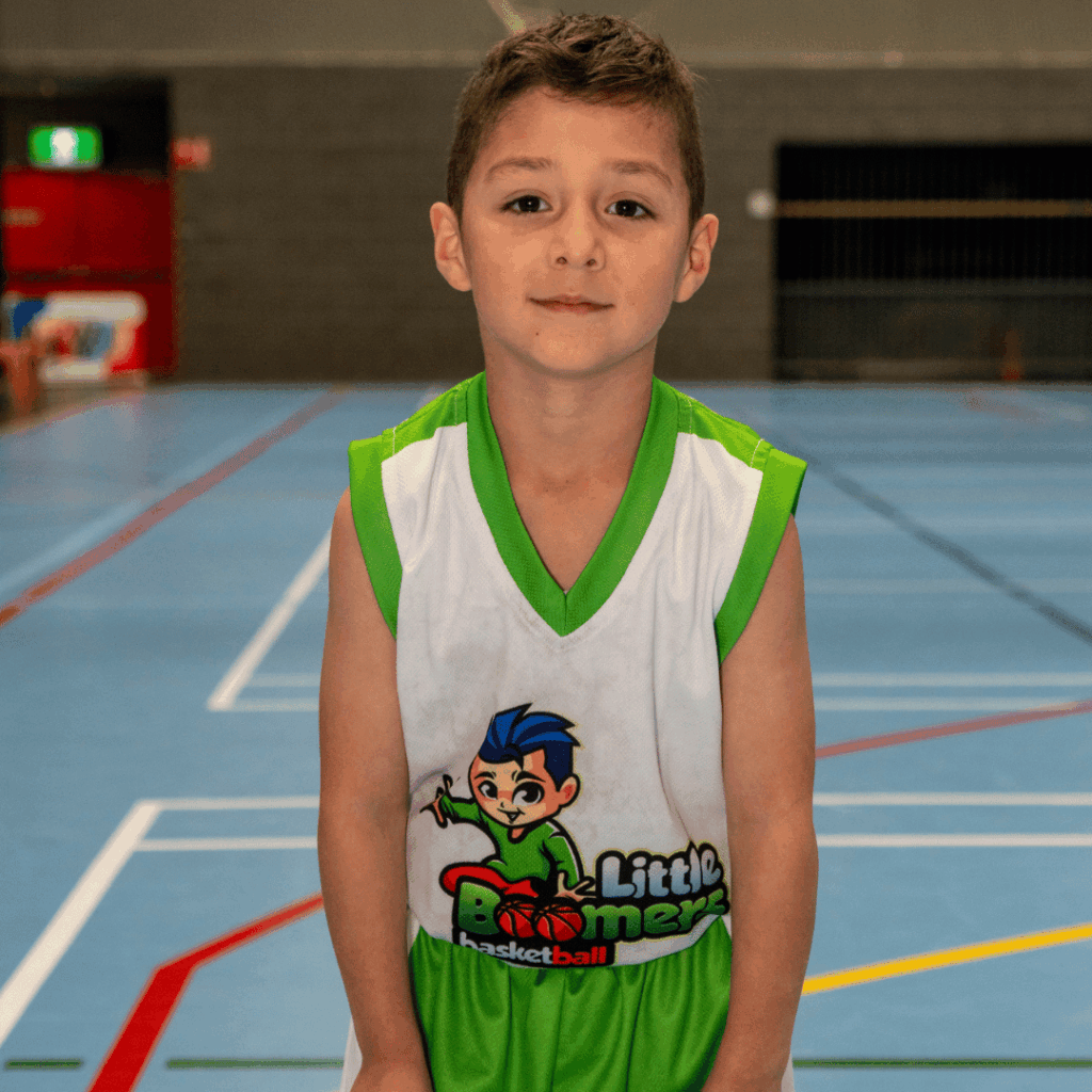 Primary school kids enjoying a basketball holiday camp indoors