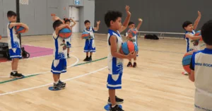 Young children engaged in a fun Little Boomers Basketball session during a group activity.