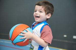 toddler smiling playing basketball