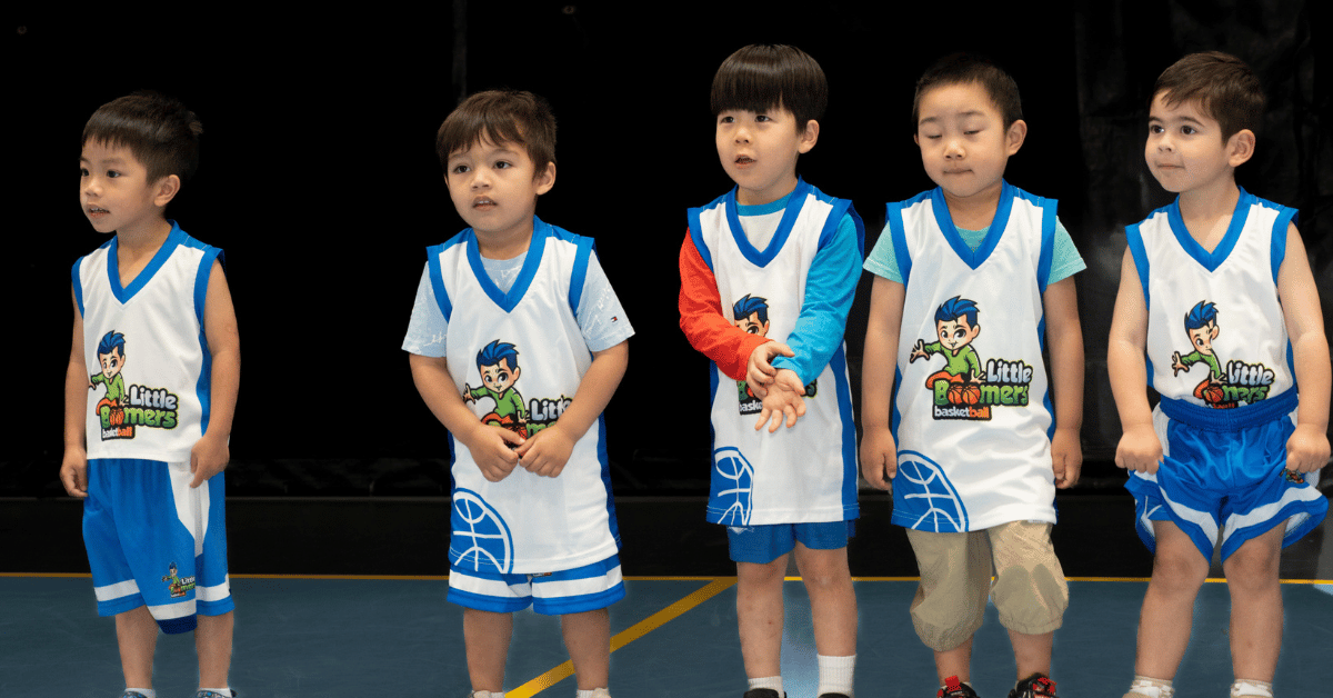 Five toddlers lined up and ready to learn basic basketball skills in a fun, safe class