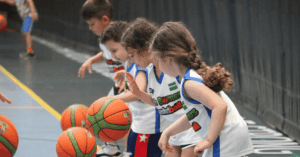Young children learning how to dribble a basketball in a toddler class
