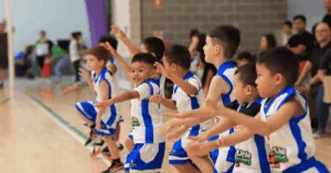 Young Mini Boomers (around 4 years old) actively playing on a basketball court
