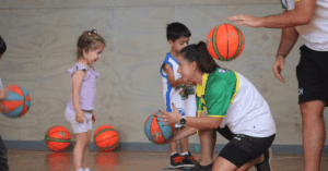 Coach helping a young girl learn basketball skills