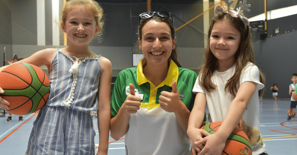 Basketball coach working with two girls during a Little Boomers training session
