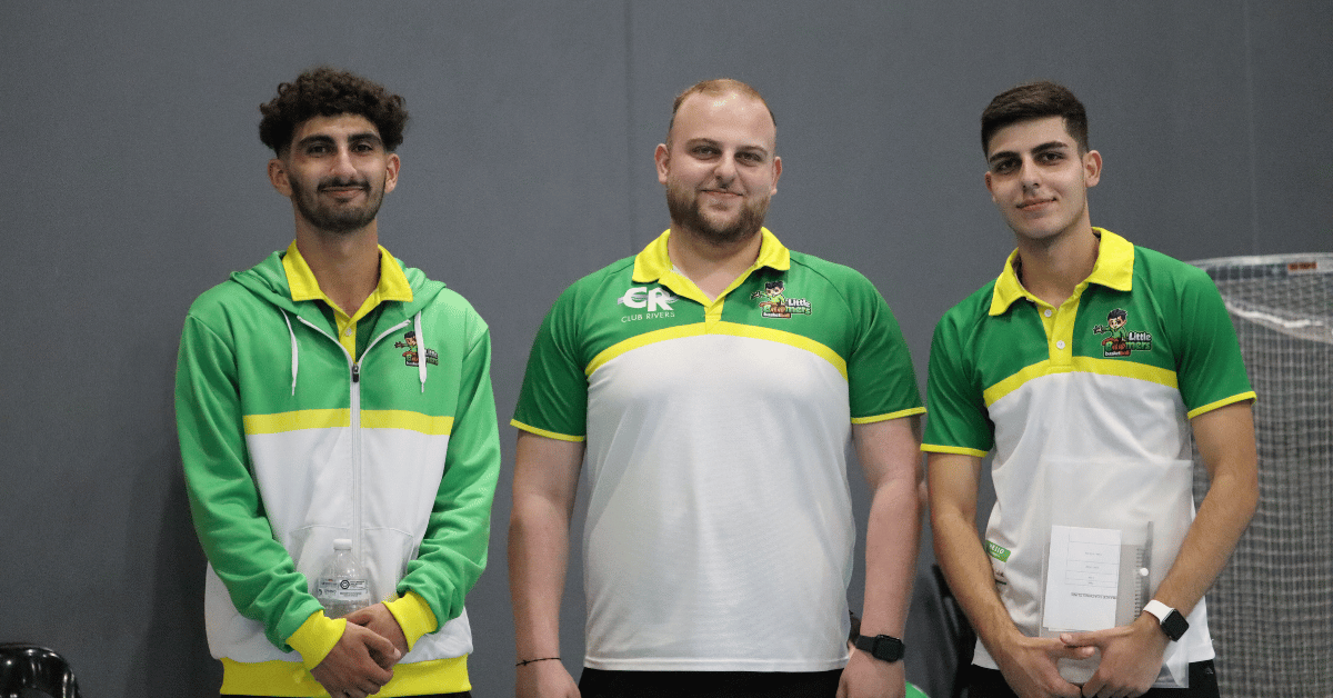 Three Little Boomers Basketball franchisees standing together inside an indoor basketball stadium during a training.
