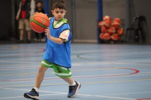 A child enjoying a Little Boomers Basketball session while participating in a fun basketball activity.
